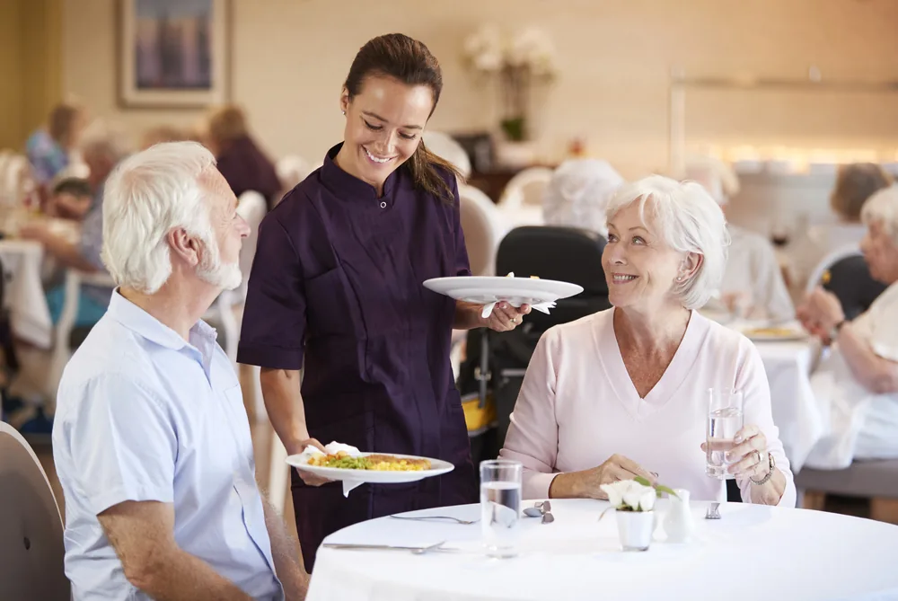 Older couple enjoying dinner after transitioning to a senior living home