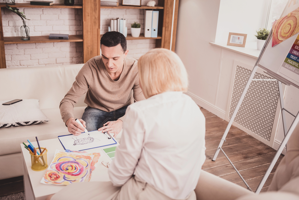 A young man and older woman doing art therapy for chronic illness