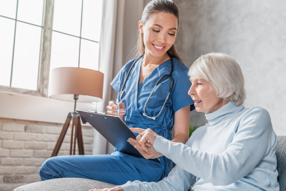 Senior woman and nurse discussing an emergency care management plan