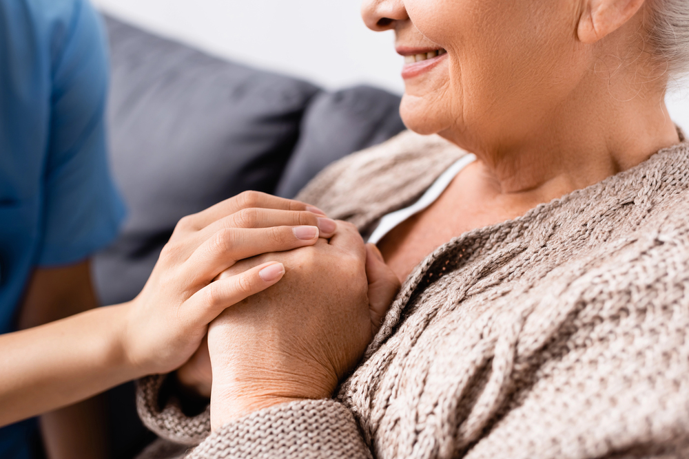 Depositphotos_426801378_S Senior woman smiling over her end of life care plan that provides peace of mind