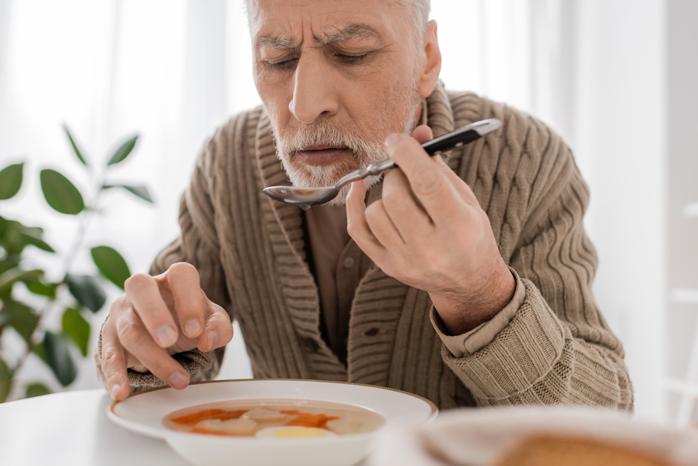 Man with special needs living independently and eating soup